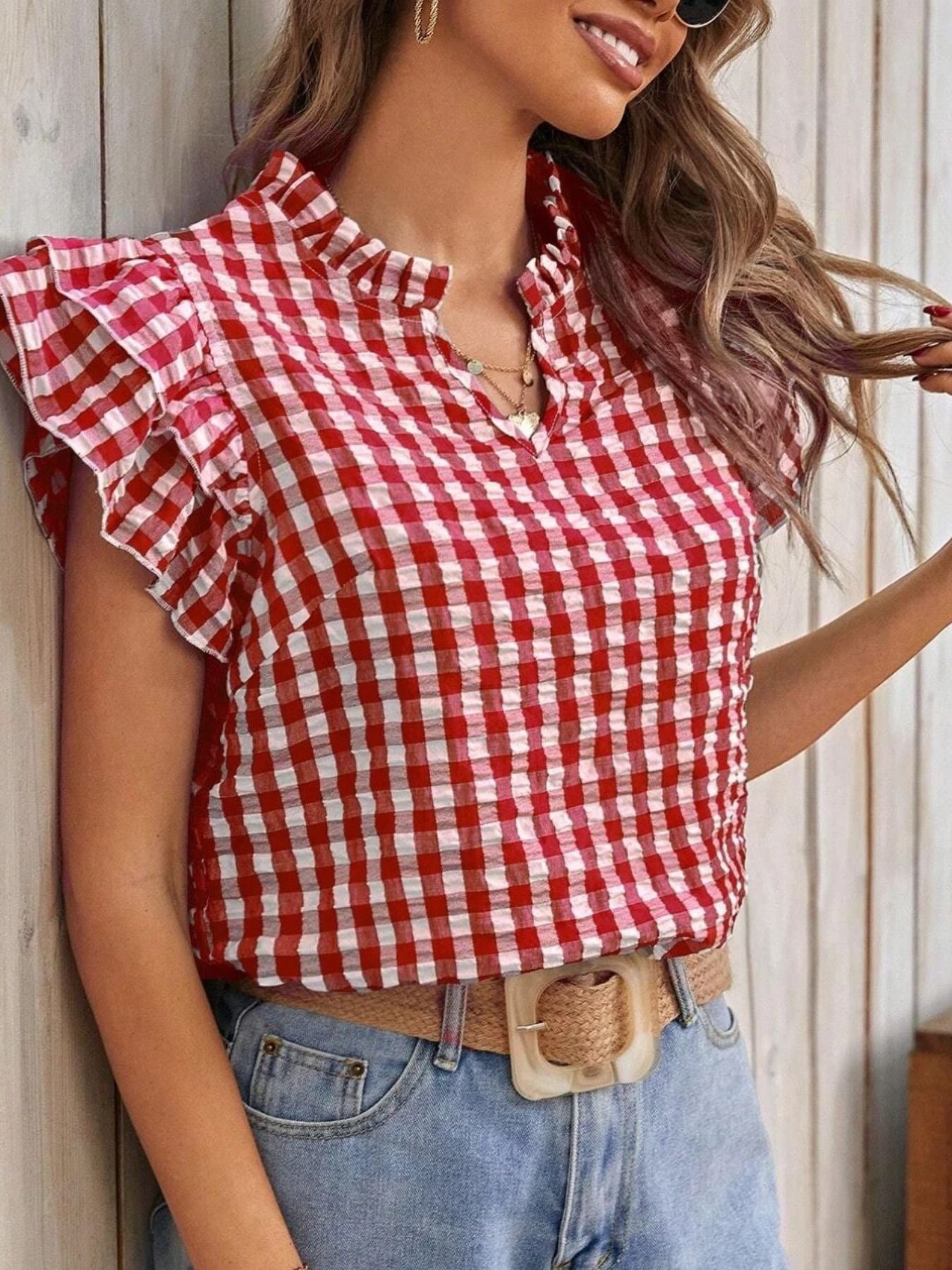Gingham ruffle sleeve blouse in red and white with a ruffled neckline.