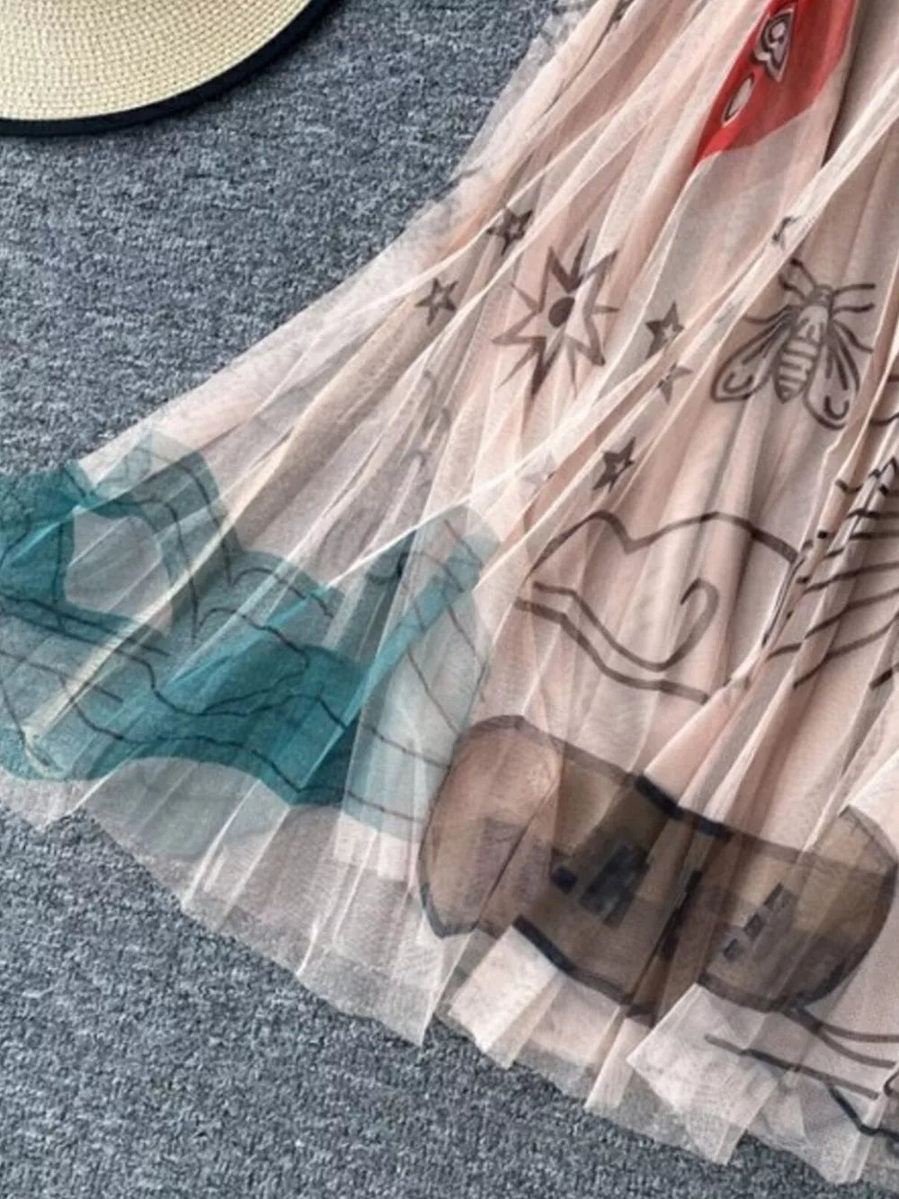 Tulle skirt in off-white with abstract sunburst, bee, and cloud print.