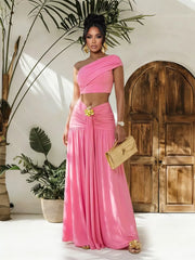 Pink one-shoulder ruched crop top and maxi skirt set with a gold flower detail.