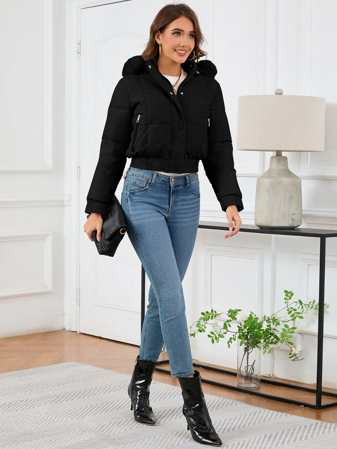 Black puffer jacket with faux fur trim, hood, and elasticated hem.