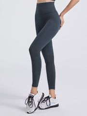 Charcoal FlexFit leggings with a wide waistband and 7/8 length, paired with white sneakers.