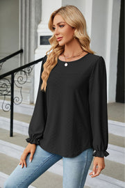 Black textured puff sleeve blouse with ruffle cuffs and round neckline.