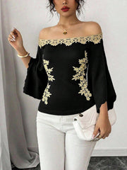 Black off-shoulder blouse with gold embroidery and bell sleeves
