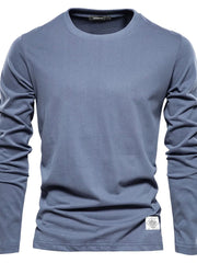 Dusty blue crew-neck long sleeve tee with textured fabric and a white patch detail.