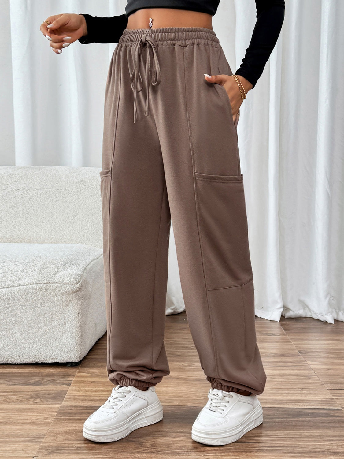 Taupe cargo joggers with adjustable drawstring waist and elastic cuffs.