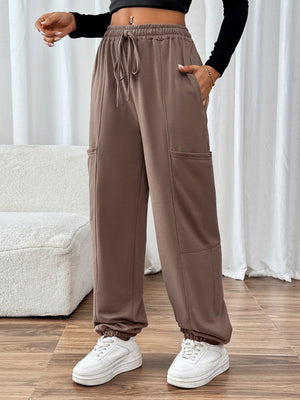 Taupe cargo joggers with adjustable drawstring waist and elastic cuffs.