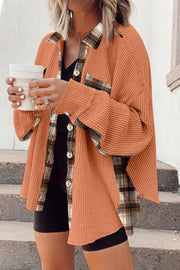 Tangerine waffle knit overshirt with plaid trim and button front, styled casually.