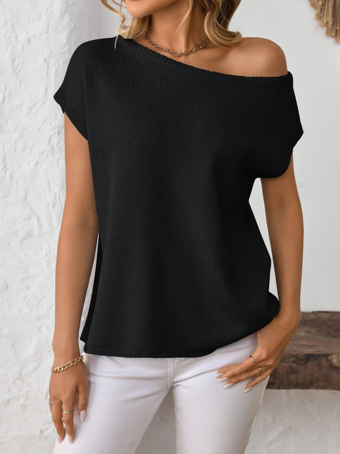 Black off-the-shoulder knit tee with short sleeves and a boat neckline.