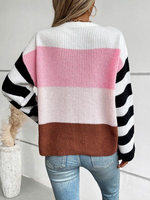 Colorblock stripe ribbed knit sweater with pink, white, and brown horizontal stripes and black and white striped sleeves.