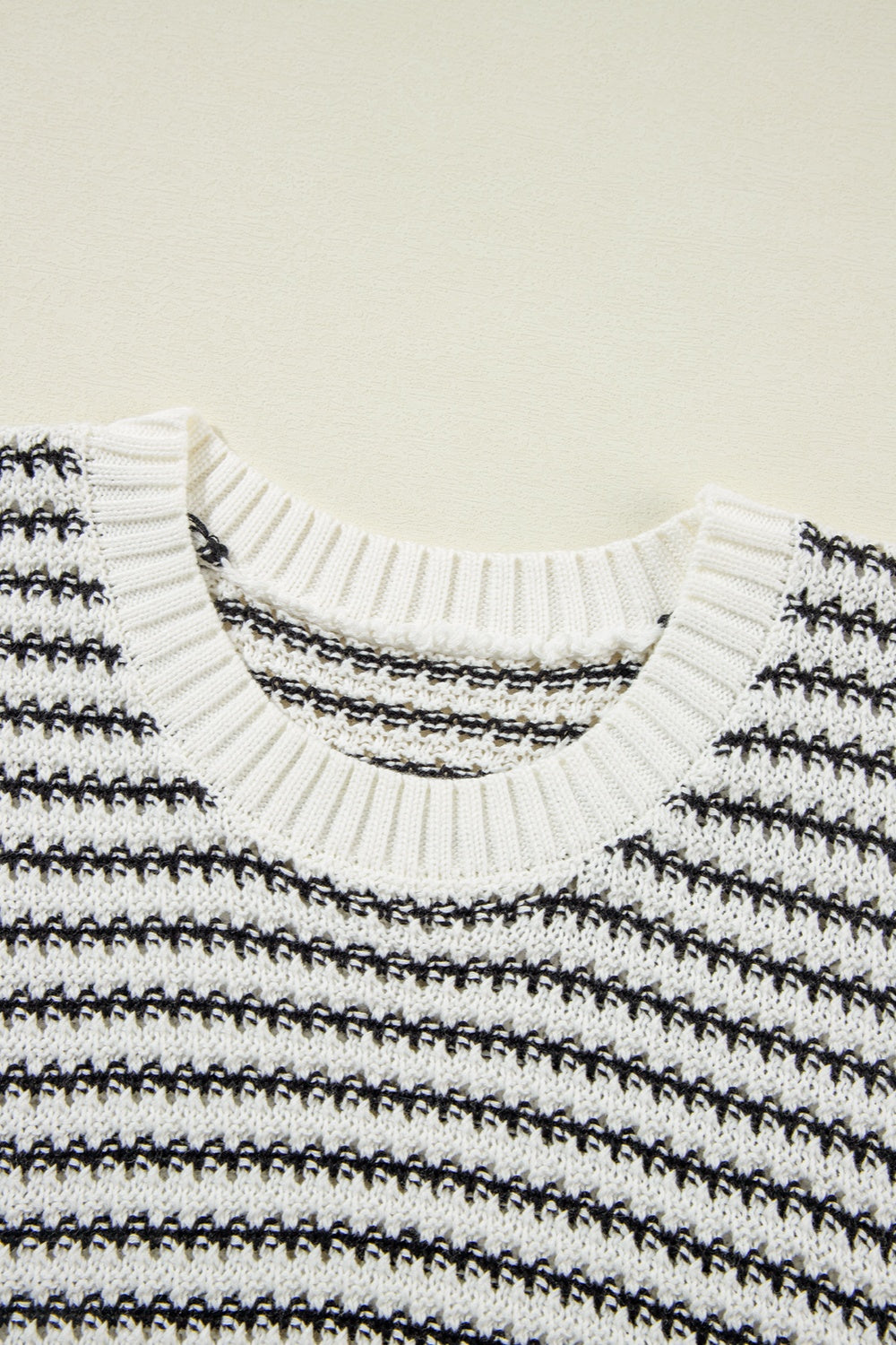 Sleeveless knit tank top in black and white stripe pattern, acrylic material, crew neck.