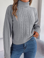 Light gray cable knit turtleneck sweater with drop shoulder and textured pattern.
