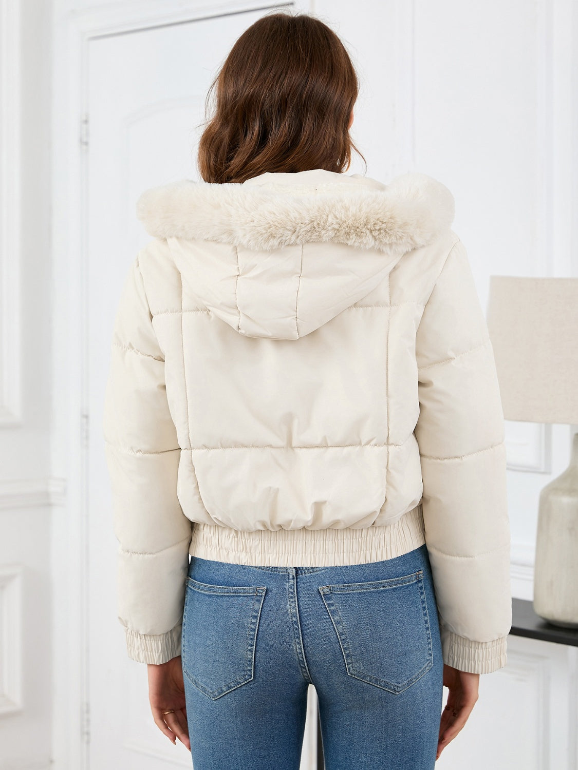 White puffer jacket with faux fur trim hood and elasticated hem.