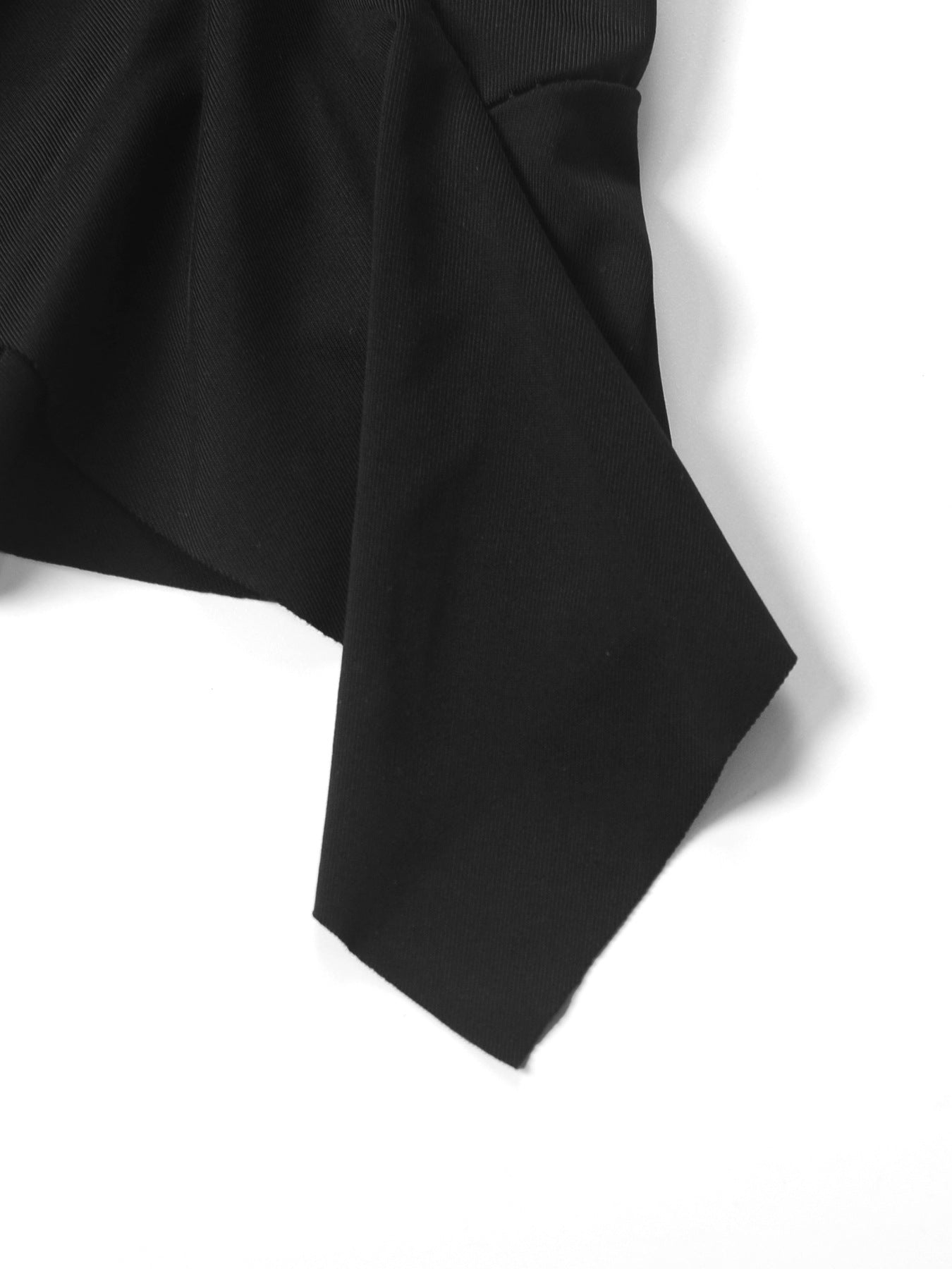 Black asymmetrical ruched mini dress detail showing dynamic silhouette and fabric texture.