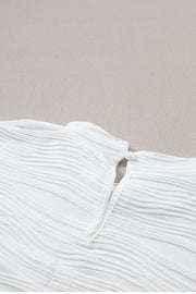 White textured cap-sleeve mock neck top with a pearl button closure at the back neck.
