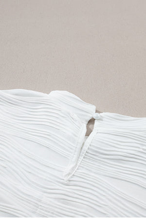 White textured cap-sleeve mock neck top with a pearl button closure at the back neck.