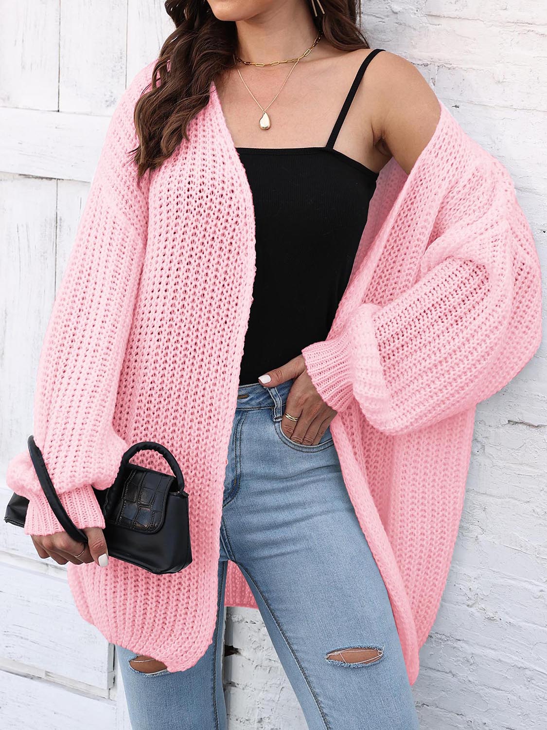 Pink balloon sleeve open knit cardigan with open front and relaxed fit.