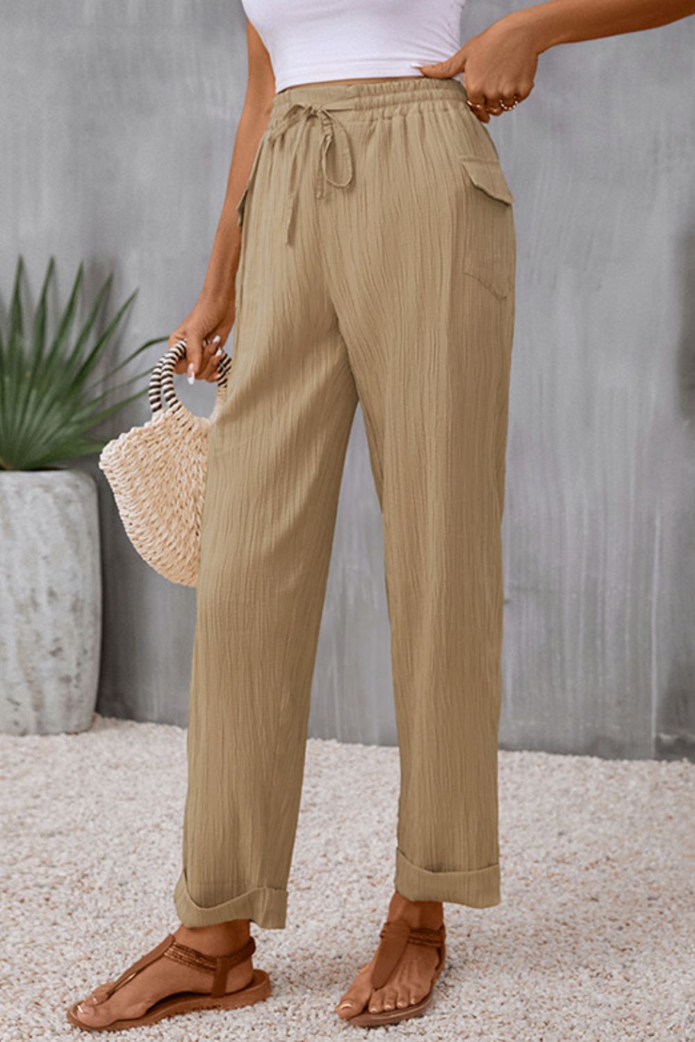 Khaki textured drawstring waistline trousers with cuffed hems and pockets.
