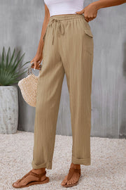 Khaki textured drawstring waistline trousers with cuffed hems and pockets.