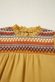 Mustard blouse with embroidered yoke and ruffled neckline.