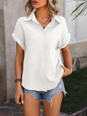 White textured button-down shirt with cuffed short sleeves and a collared neckline.