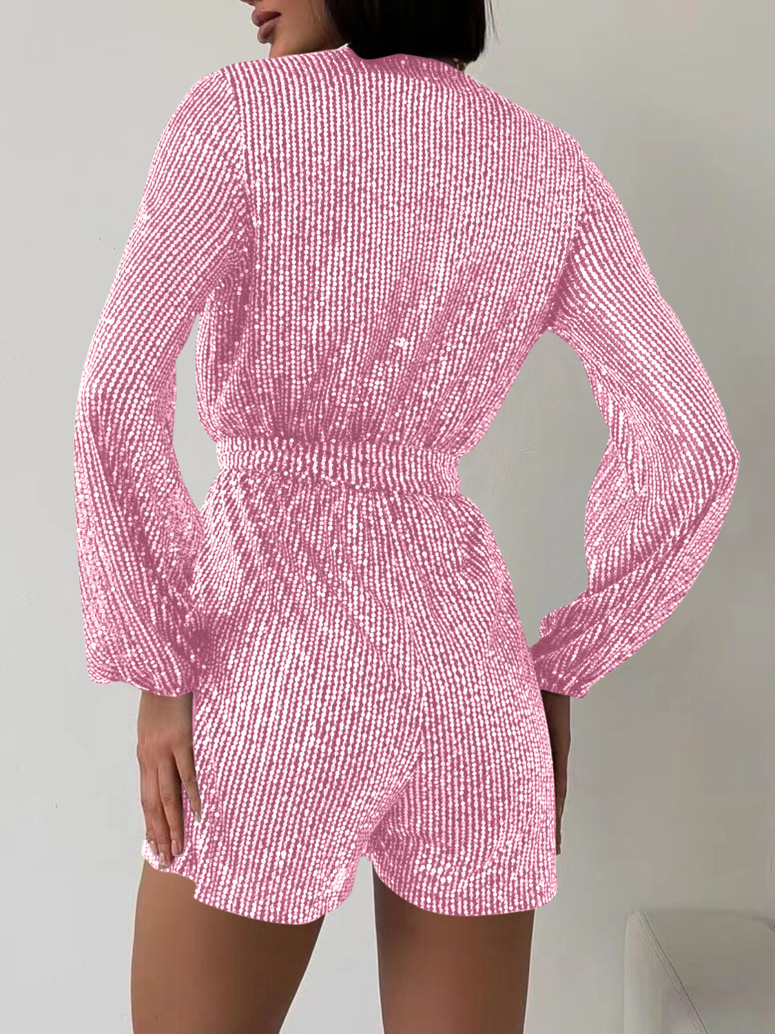 Pink sequin wrap romper with blouson sleeves and cinched waist