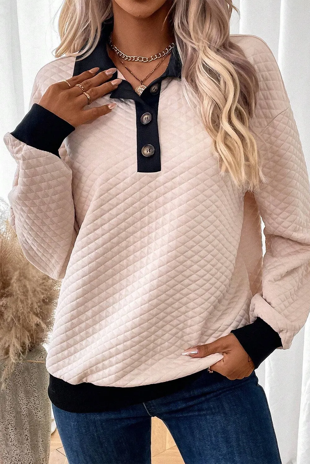 Diamond quilted polo sweatshirt in tan with black collar and cuffs, featuring button detail.