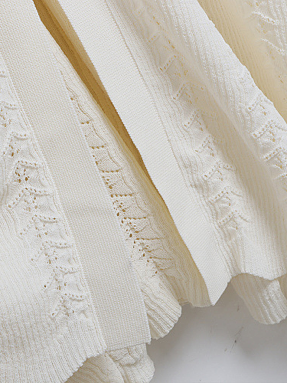 Cream ribbed knit maxi dress with decorative button detail and openwork pattern.