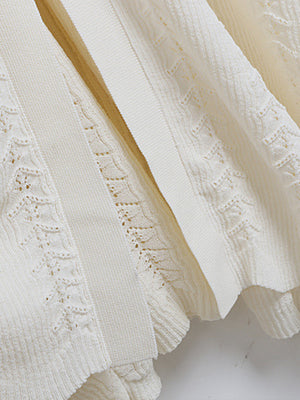 Cream ribbed knit maxi dress with decorative button detail and openwork pattern.