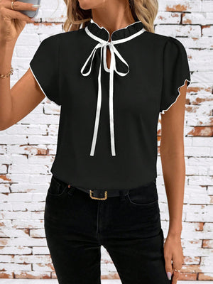 Black maternity blouse with frilled tie-neck and white trim.