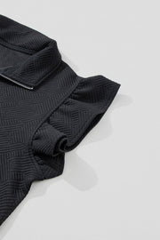 Black zip-up loungewear top with textured geometric pattern and ruffle sleeves