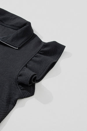 Black zip-up loungewear top with textured geometric pattern and ruffle sleeves
