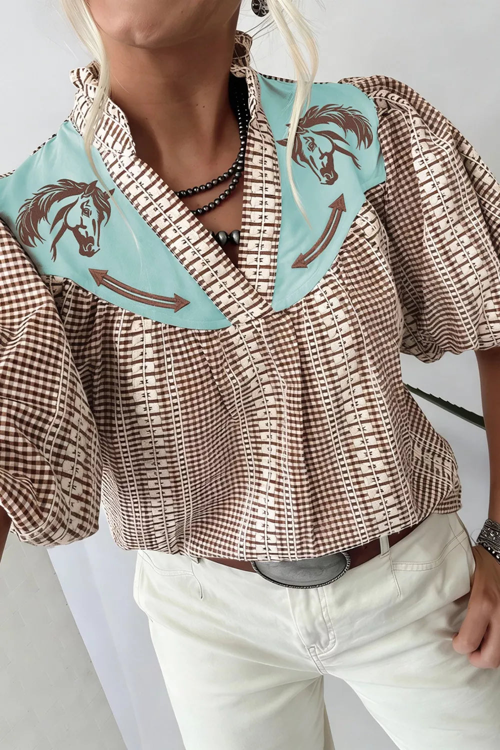Brown gingham puff sleeve shirt with embroidered horse yoke and contrast trim.