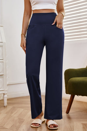 Navy high-waisted flare leg trousers with pockets, styled casually.