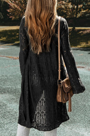 Black openwork maxi cardigan with intricate knit details and bell sleeves.