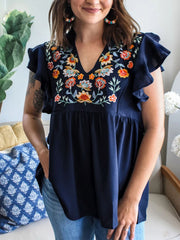 Navy embroidered floral blouse with ruffle sleeves and V-neck