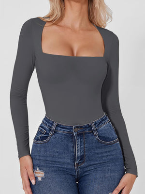 Dark gray long sleeve bodysuit with a square neckline, paired with blue jeans.
