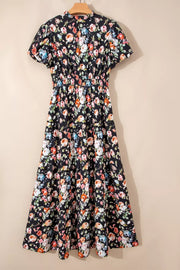 Black floral tiered maxi dress with smocked waist and short sleeves.