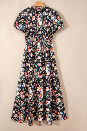 Black floral tiered maxi dress with smocked waist and short sleeves.