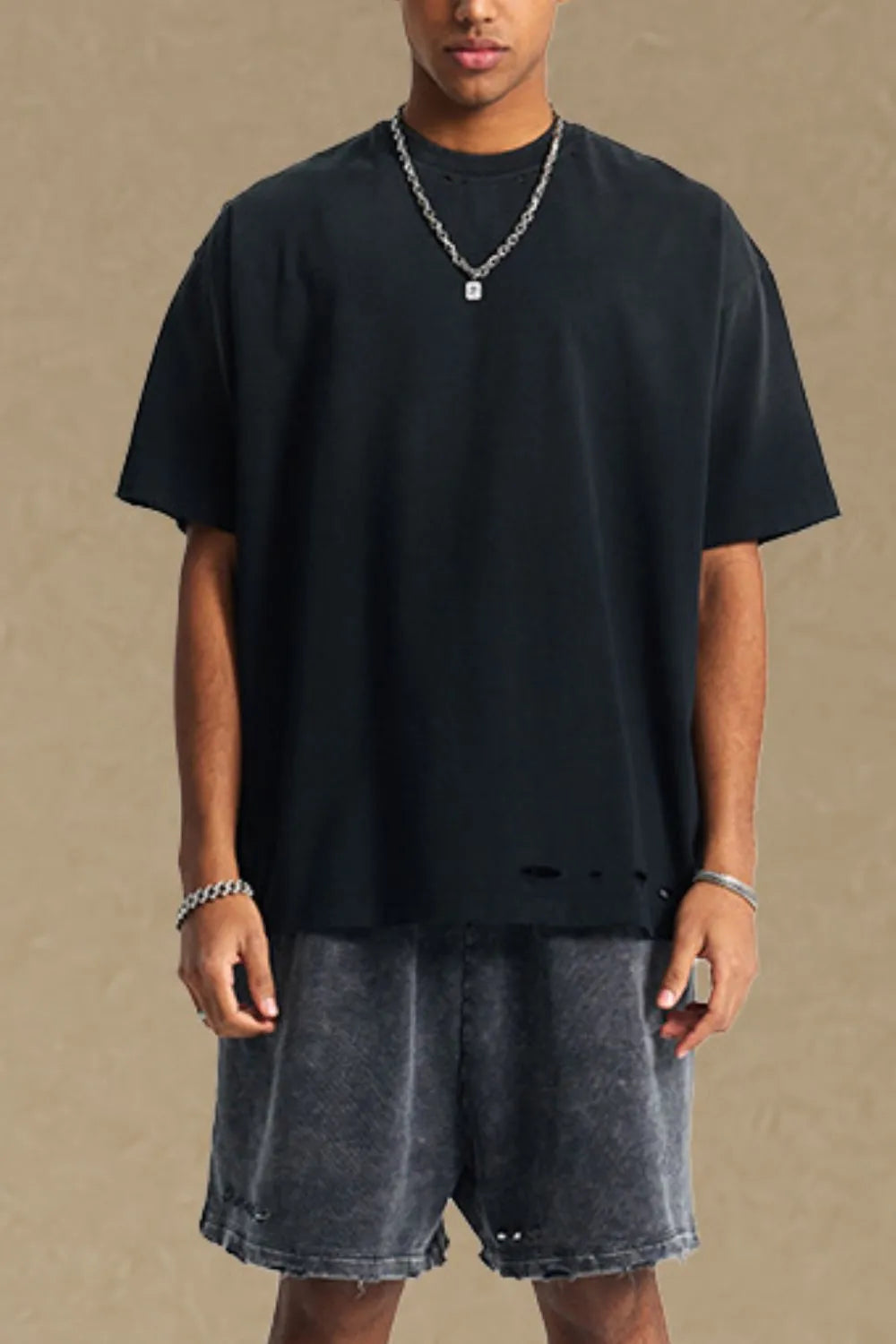 Black oversized tee with distressed hemline and short sleeves.