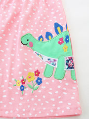 Baby dress with pink polka dots, green dinosaur appliqué, and floral accents.