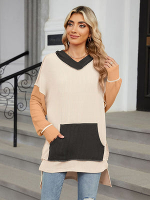 Waffle knit tunic with contrast colorblock sleeves, V-neck, and front pocket.