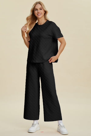 Black textured knit loungewear set with wide leg pants and short sleeve top.