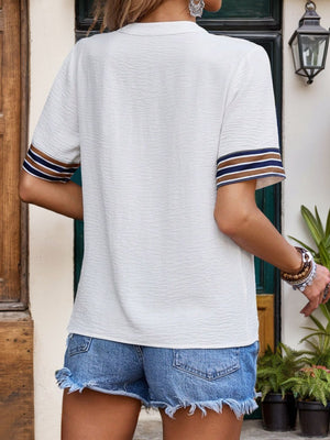White textured blouse with striped trim on short sleeves and V-neck.