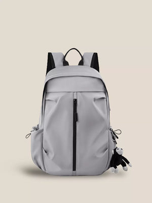 Gray nylon drawstring backpack with monkey keychain and zippered front pocket.