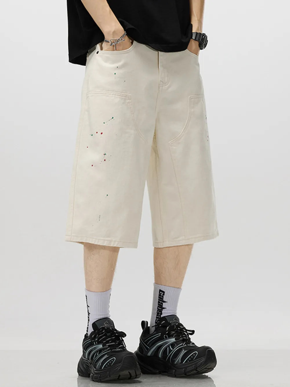 Cream cotton denim capris with artistic paint splatters, relaxed fit, and casual style.