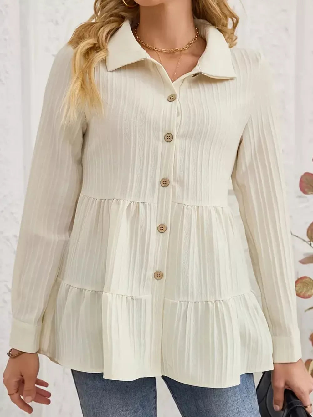 Cream textured tiered button-down shirt with collared neckline and long sleeves.