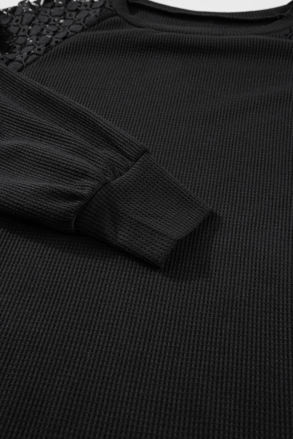 Black waffle knit raglan top with lace yoke detail and cuffed sleeves.