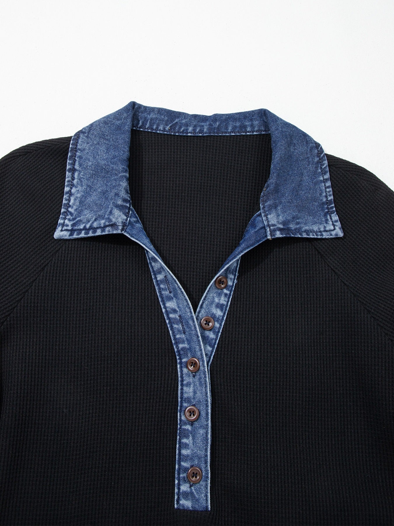 Black textured knit polo top with denim collar and button placket.