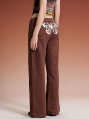 Brown wide-leg jeans with a white butterfly back detail.