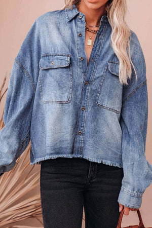 Light wash denim oversized shirt with raw hem and button-down front.